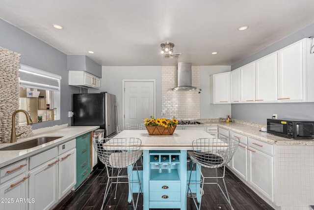 2802 E Virginia Ave, Phoenix, AZ 85008 - kitchen with wall chimney range hood, black microwave, a breakfast bar, white cabinetry, and freestanding refrigerator