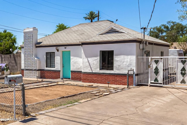 2802 E Virginia Ave, Phoenix, AZ 85008 - view of front facade featuring stucco siding, a gate, brick siding, a chimney, and a shingled roof