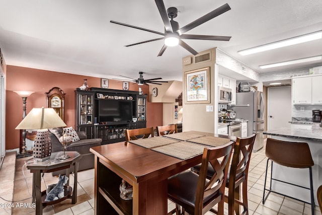 tiled dining space featuring ceiling fan