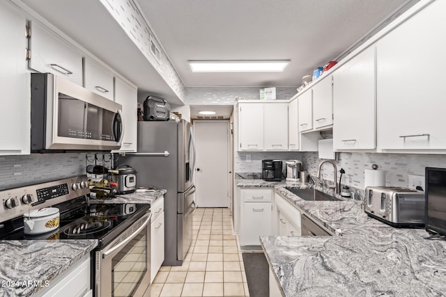 kitchen featuring white cabinets, light tile patterned flooring, sink, and stainless steel appliances