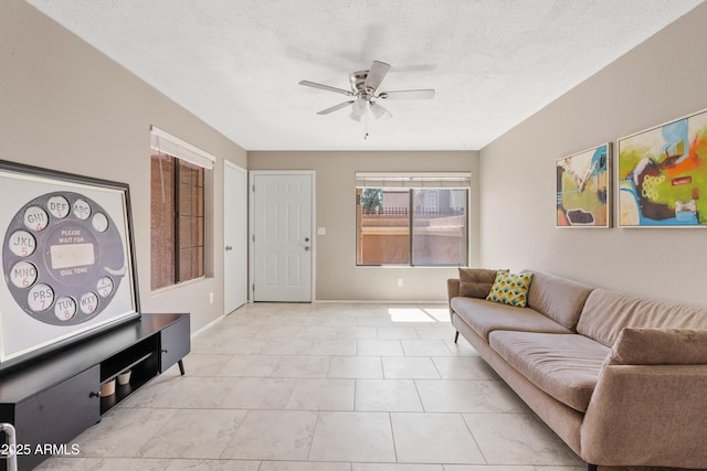 living room with ceiling fan and a textured ceiling