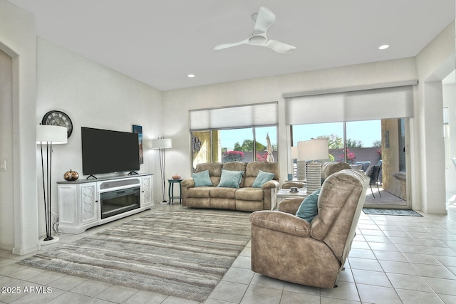 tiled living room featuring ceiling fan and a wealth of natural light