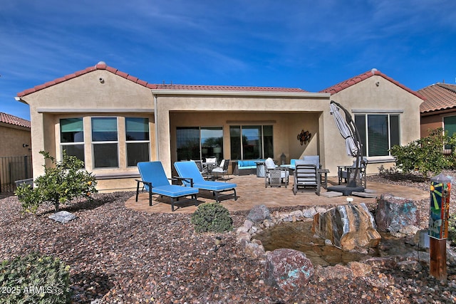 rear view of property featuring outdoor lounge area and a patio