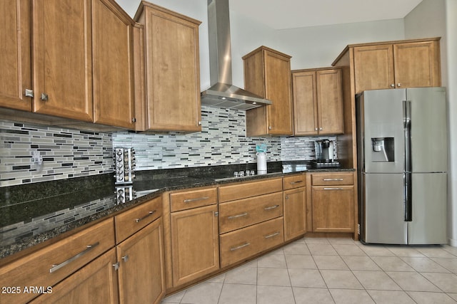 kitchen featuring stainless steel fridge with ice dispenser, tasteful backsplash, wall chimney exhaust hood, and light tile patterned flooring