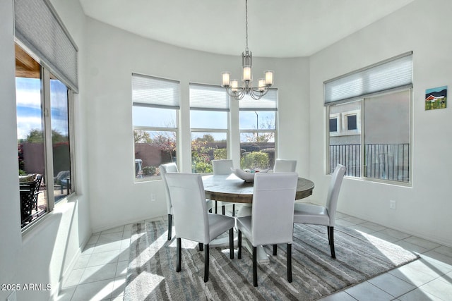 tiled dining space with a healthy amount of sunlight and a chandelier