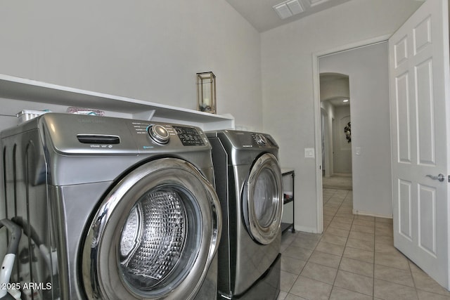 washroom featuring washer and dryer and light tile patterned flooring