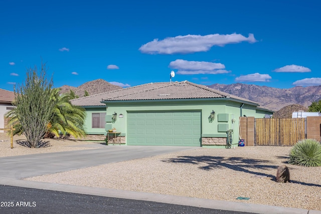 ranch-style home with stucco siding, a mountain view, and a tiled roof