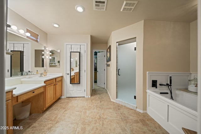 bathroom with a closet, vanity, visible vents, and a stall shower