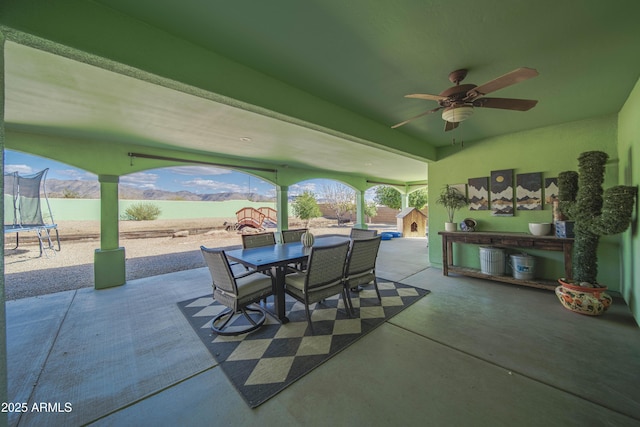 view of patio with a trampoline and outdoor dining area