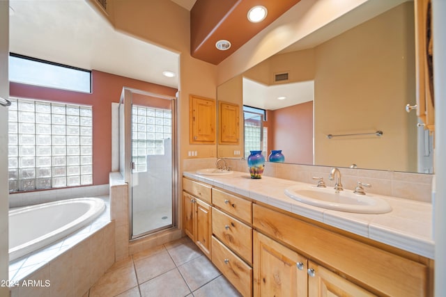 bathroom with tile patterned flooring, vanity, and separate shower and tub