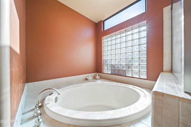 bathroom featuring a wealth of natural light and a relaxing tiled tub