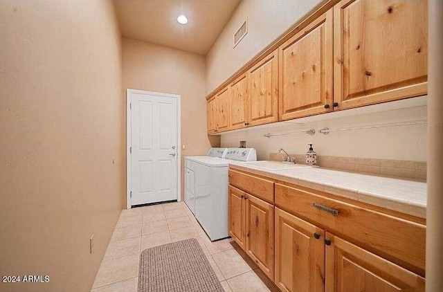 clothes washing area featuring cabinets, independent washer and dryer, sink, and light tile patterned floors