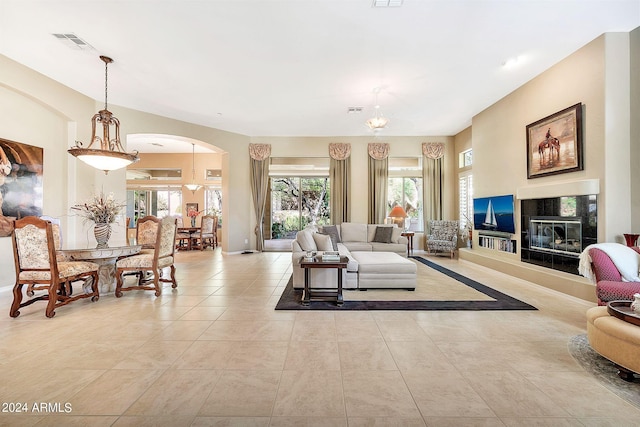 tiled living room with a chandelier and a tile fireplace