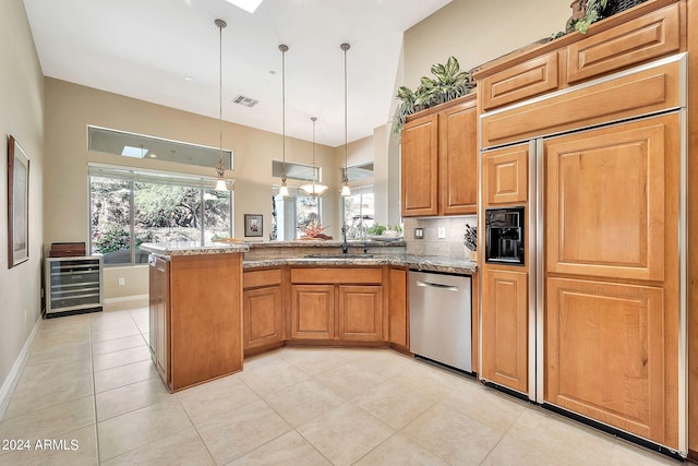 kitchen featuring dishwasher, wine cooler, sink, decorative light fixtures, and light stone countertops