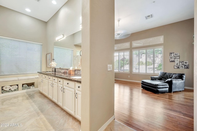 bathroom with vanity, a towering ceiling, and hardwood / wood-style floors