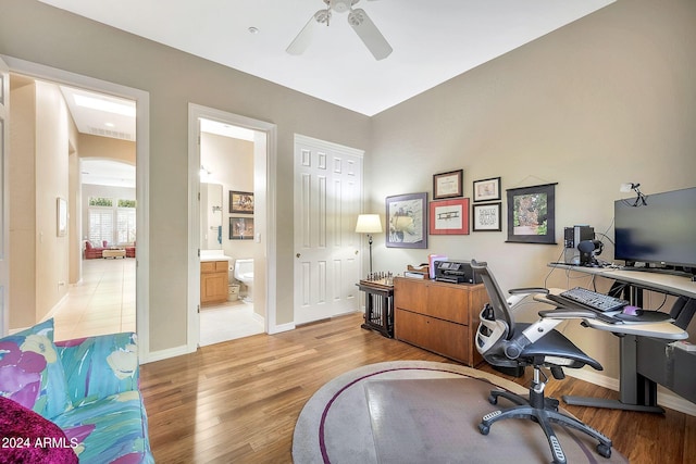 office with light wood-type flooring and ceiling fan