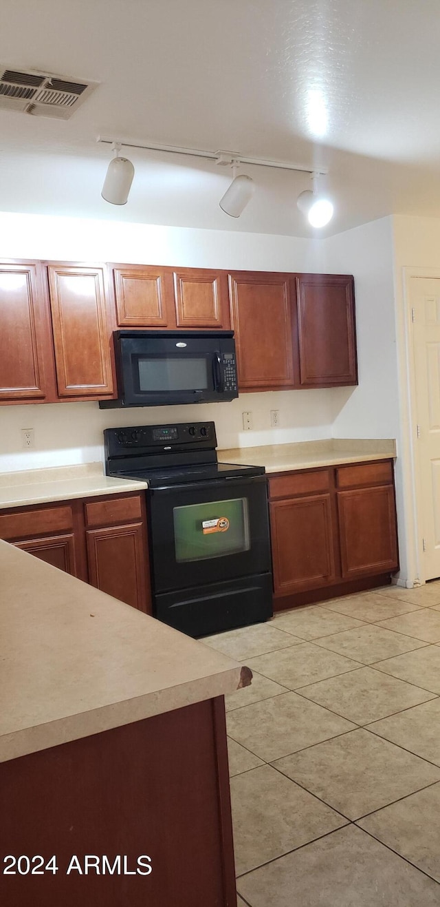 kitchen featuring black appliances, rail lighting, and light tile patterned floors