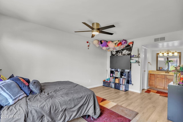 3500 N Hayden Rd Unit 203, Scottsdale, AZ 85251 - bedroom with light wood-style floors, a sink, baseboards, a ceiling fan, and connected bathroom
