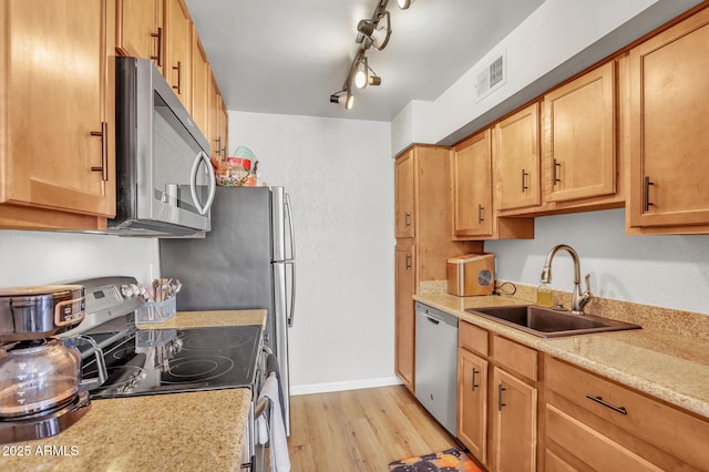 3500 N Hayden Rd Unit 203, Scottsdale, AZ 85251 - kitchen with stainless steel appliances, a sink, light wood finished floors, baseboards, and track lighting