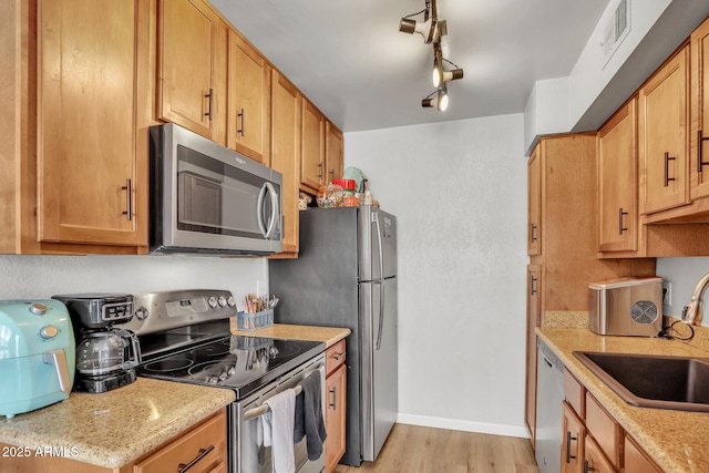 3500 N Hayden Rd Unit 203, Scottsdale, AZ 85251 - kitchen with appliances with stainless steel finishes, a sink, light wood-style floors, baseboards, and rail lighting