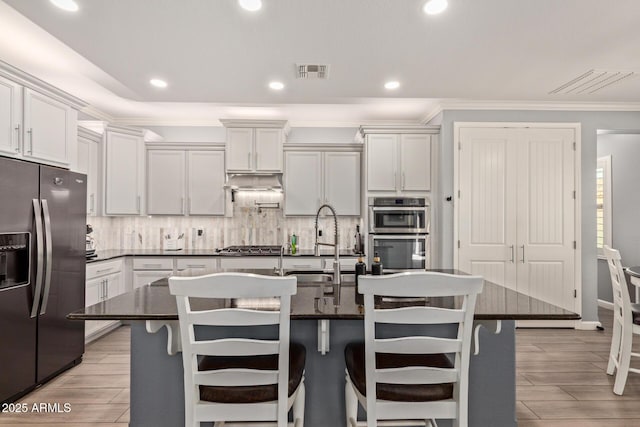 kitchen featuring dark countertops, visible vents, tasteful backsplash, double oven, and fridge with ice dispenser