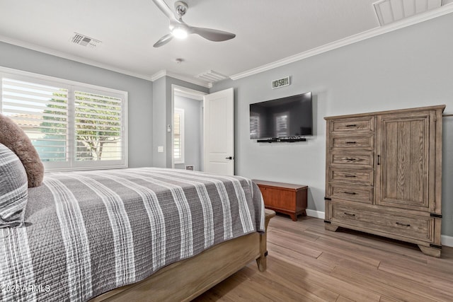 bedroom with visible vents, crown molding, light wood-type flooring, and a ceiling fan