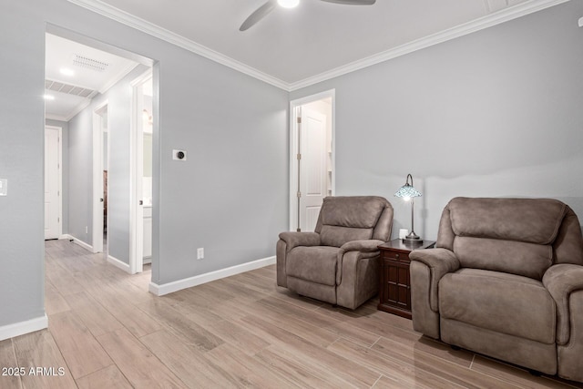 sitting room featuring light wood-style flooring, baseboards, visible vents, and ornamental molding