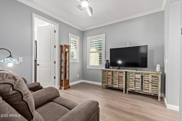 living area featuring visible vents, ceiling fan, baseboards, ornamental molding, and wood finished floors