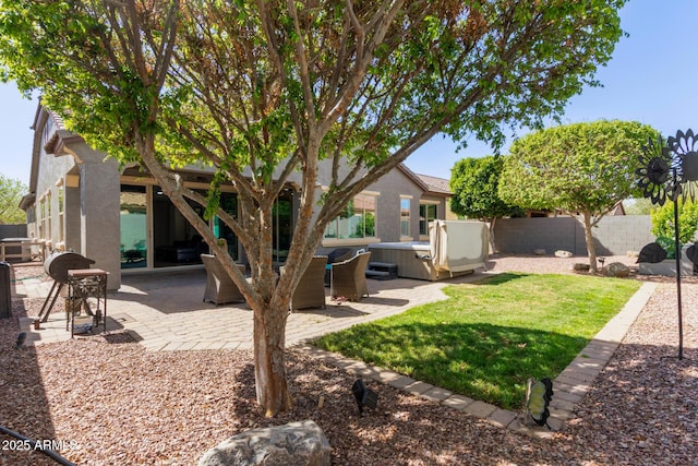 view of yard featuring a patio, fence, and a hot tub