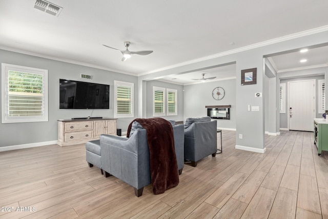 living room with visible vents, light wood-style flooring, baseboards, and ceiling fan