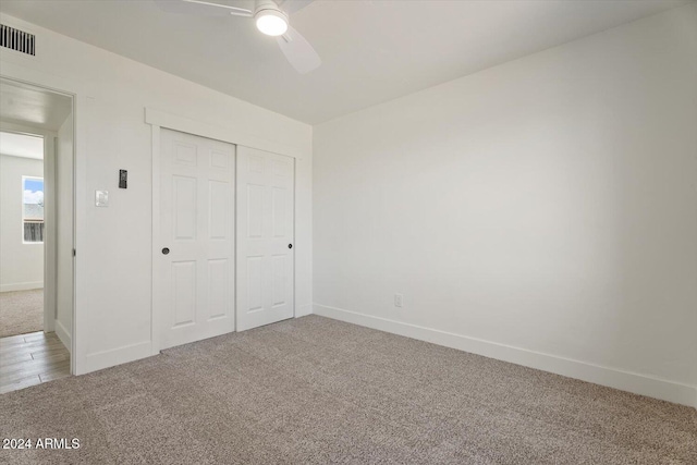 unfurnished bedroom with a closet, carpet flooring, and ceiling fan