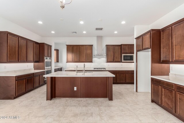 8628 W Solano Dr, Glendale, AZ 85305 - kitchen featuring wall chimney exhaust hood, stainless steel appliances, a sink, an island with sink, and light countertops