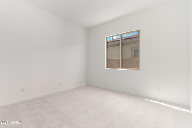 spare room featuring light colored carpet