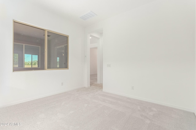 unfurnished room featuring light carpet