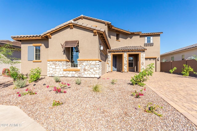 8628 W Solano Dr, Glendale, AZ 85305 - mediterranean / spanish-style house featuring stone siding, stucco siding, decorative driveway, and a tiled roof