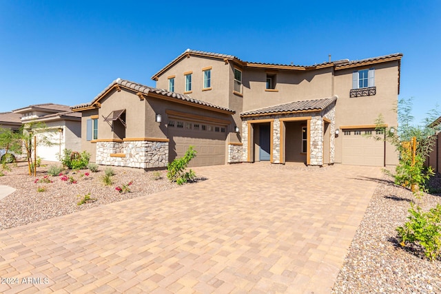 8628 W Solano Dr, Glendale, AZ 85305 - mediterranean / spanish-style house featuring stone siding, stucco siding, decorative driveway, and a tiled roof