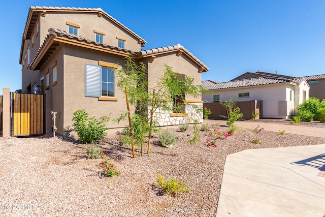 8628 W Solano Dr, Glendale, AZ 85305 - mediterranean / spanish-style house featuring stucco siding, a gate, and a tile roof