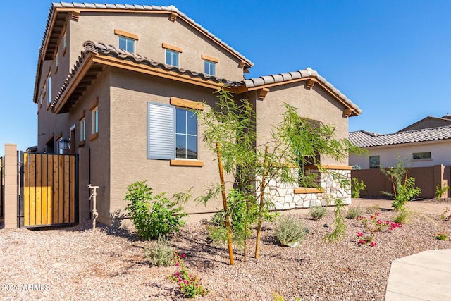 8628 W Solano Dr, Glendale, AZ 85305 - view of front facade with stucco siding, a gate, and a tile roof