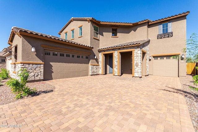 8628 W Solano Dr, Glendale, AZ 85305 - mediterranean / spanish home with stone siding, decorative driveway, stucco siding, and a tile roof