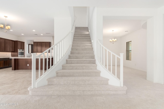 stairway featuring an inviting chandelier and carpet floors