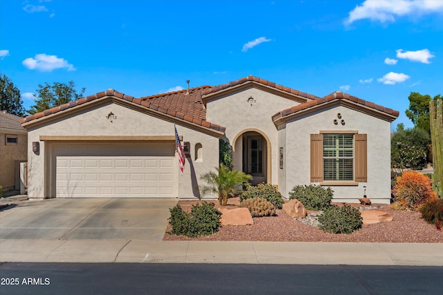 mediterranean / spanish-style house with driveway, an attached garage, a tiled roof, and stucco siding