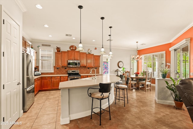 kitchen with brown cabinets, stainless steel appliances, light countertops, visible vents, and decorative backsplash