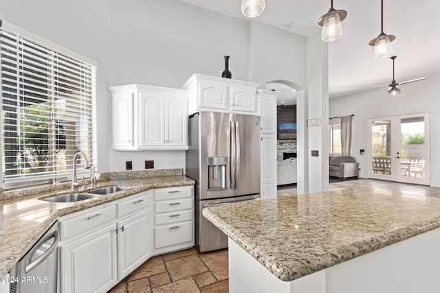 2731 W Desert Ranch Rd, Phoenix, AZ 85086 - kitchen featuring appliances with stainless steel finishes, a sink, white cabinets, arched walkways, and light stone countertops