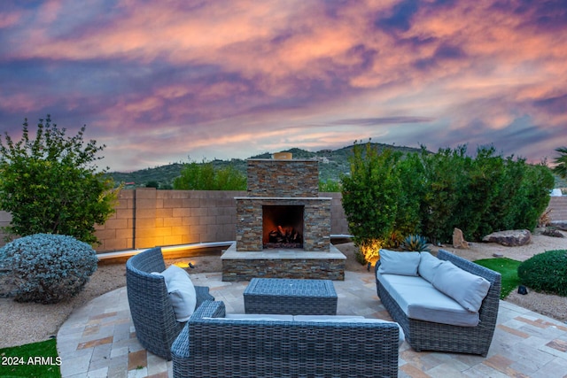 2731 W Desert Ranch Rd, Phoenix, AZ 85086 - patio terrace at dusk featuring a patio and an outdoor living space with a fireplace