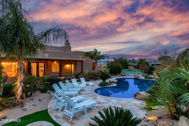 2731 W Desert Ranch Rd, Phoenix, AZ 85086 - pool at dusk featuring an outdoor pool and a patio
