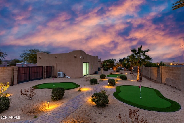 2731 W Desert Ranch Rd, Phoenix, AZ 85086 - back of property at dusk with a putting green, a fenced backyard, a patio area, stucco siding, and ac unit