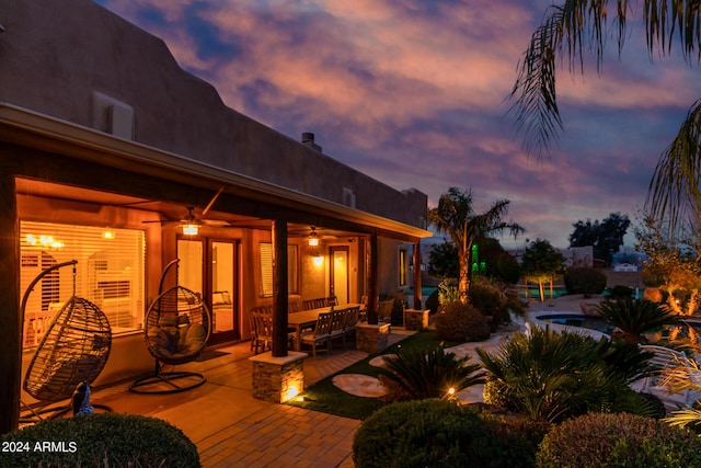 2731 W Desert Ranch Rd, Phoenix, AZ 85086 - patio terrace at dusk featuring a patio, ceiling fan, outdoor lounge area, and an outdoor pool