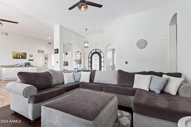 2731 W Desert Ranch Rd, Phoenix, AZ 85086 - living room featuring a ceiling fan, arched walkways, dark wood-style flooring, a high ceiling, and bar area