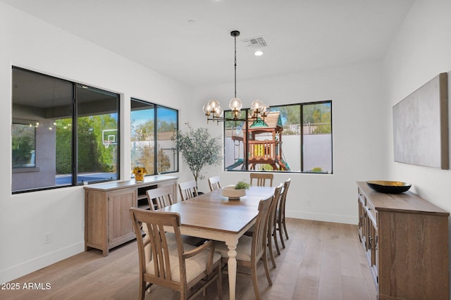 dining space with an inviting chandelier, light hardwood / wood-style flooring, and a healthy amount of sunlight