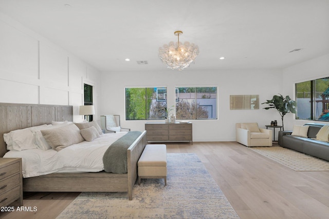 bedroom with an inviting chandelier and light hardwood / wood-style floors